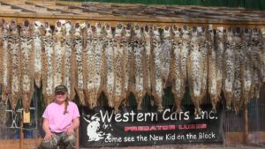 Western Cats inc image of Reilee Helms in front of trapping furs